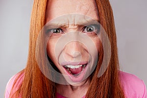 Redhair ginger woman feeling angry and irritation studio background fish eye