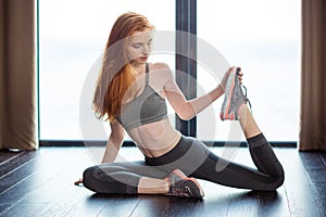 Redhair woman stretching legs photo