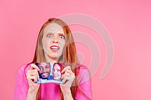 redhaired ginger sad woman tearing photo of happy international couple