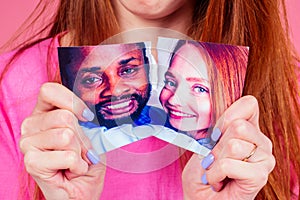 redhaired ginger sad woman tearing photo of happy international couple