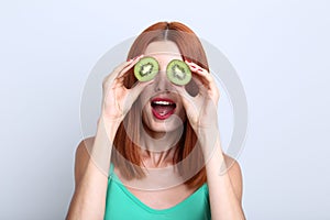 Redhaired woman with kiwi fruit