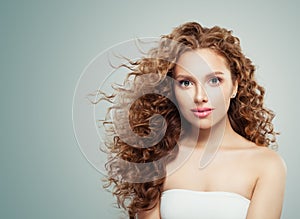 Redhead beauty. Young female face, woman with long healthy wavy hair