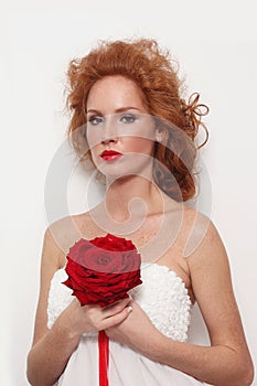 Redhead bride with fancy prom hairdo and red rose