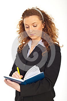 Redhead business woman writing in agenda