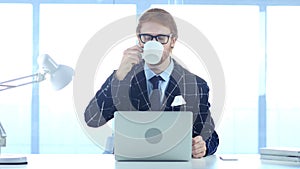 Redhead Businessman Relaxing and Drinking Coffee at Work