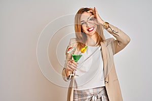 Redhead caucasian business woman drinking a summer cocktail over isolated background with happy face smiling doing ok sign with