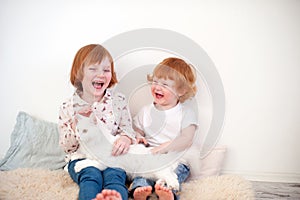 Redhead children play with a cat