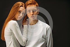 Redhead couple posing together at camera isolated in studio