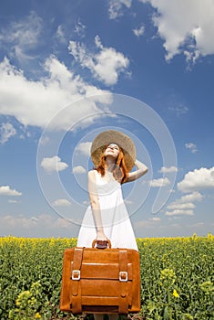 Redhead enchantress with suitcase