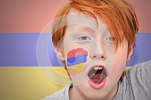 Redhead fan boy with armenian flag painted on his face