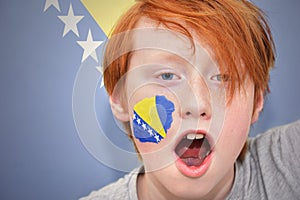 Redhead fan boy with bosnia and herzegovina flag painted on his face