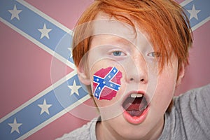 Redhead fan boy with confederate flag painted on his face.