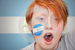 Redhead fan boy with nicaraguan flag painted on his face