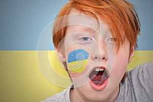 Redhead fan boy with ukrainian flag painted on his face