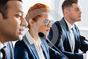 Redhead female politician in eyeglasses, sitting