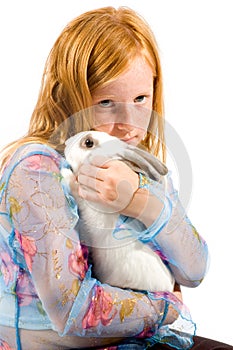 Redhead girl is cuddling with a white rabbit