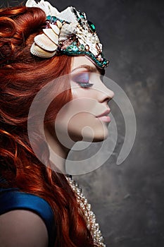 Redhead girl fabulous look, blue long dress, bright makeup and big eyelashes. Mysterious fairy woman with red hair. Big eyes