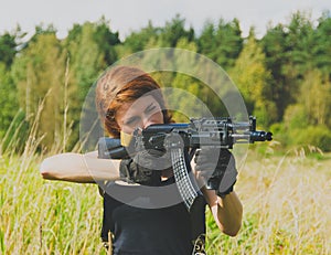 Redhead girl with a gun in his hand