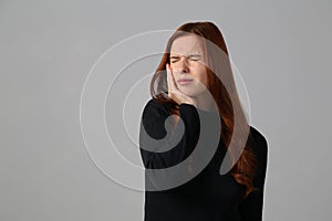 The redhead girl has awful toothache at gray background her home