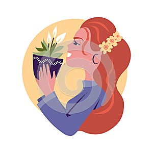 The redhead girl holding a plant pot and rejoicing. The house flowers, peace lily. The happy woman