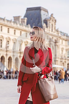 Redhead girl in red coat and bag on parisian street