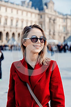 Redhead girl in red coat and bag on parisian street