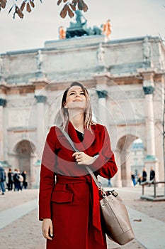 Redhead girl in red coat and bag on parisian street