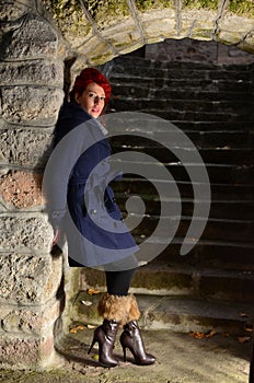 Redhead girl standing by the wall