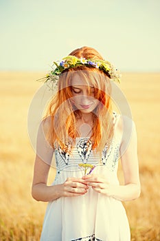 Redhead girl at summer wheat field