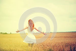 Redhead girl at summer wheat field