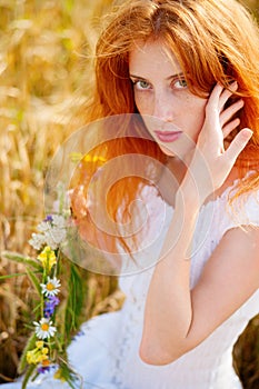 Redhead girl at summer wheat field