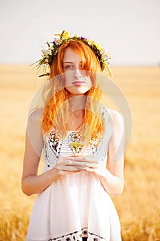 Redhead girl at summer wheat field