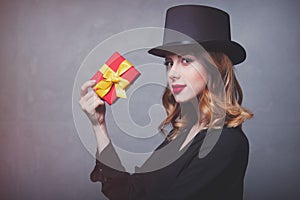 Redhead girl in top hat with gift box
