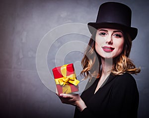 Redhead girl in top hat with gift box