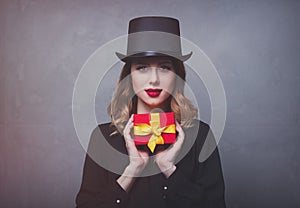 Redhead girl in top hat with gift box