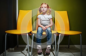 Redhead girl waiting in reception room.