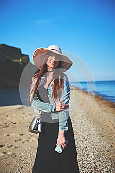 Redhead girl wearing black dress and jeans jacket. Straw hat. Ho