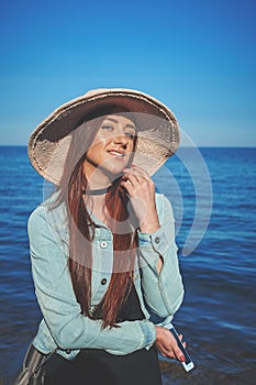 Redhead girl wearing black dress and jeans jacket. Straw hat. Ho