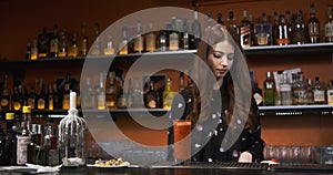 Redhead girl Young adult woman bartender prepares mixes bloody mery cocktail at the bar