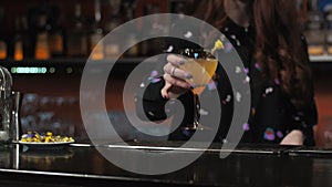 Redhead girl Young adult woman bartender prepares mixes paper airplane cocktail at the bar