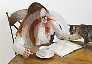 Redhead with Glasses pets her cat