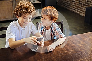 Redhead little boy listening to music with older brother