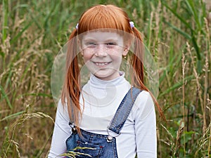 redhead little girl with freckles smiles brightly