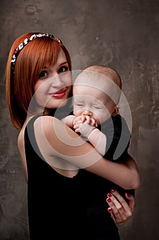 Redhead mother holding her sleepy baby boy photo