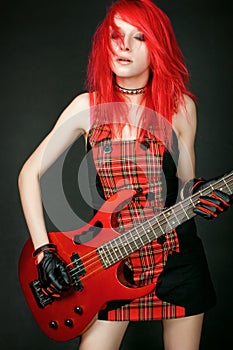 Redhead rocker girl with bass guitar