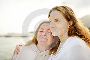 Redhead senior mother and her beautiful adult daughter are walking together and laughing