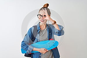 Redhead student woman wearing backpack holding skate over isolated white background with happy face smiling doing ok sign with