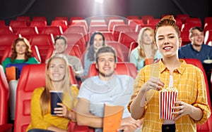 Redhead teenage girl with popcorn at movie theater