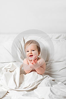 Redhead Toddler on bed smiles. Infant development concept, toddler restful sleep, teething, colic