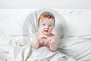 Redhead Toddler on bed smiles. Infant development concept, toddler restful sleep, teething, colic